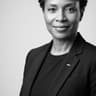 Black and white professional portrait of senior female healthtech advisory specialist in sharp tailored blazer, clean studio lighting