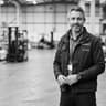Monochrome portrait of a head of supply chain systems in industrial technical attire.