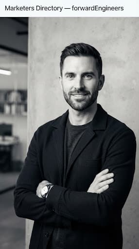 Refined portrait of Julian Sterling, a male tech product marketer in a dark tailored overshirt, subtle concrete texture background, high-contrast studio softbox lighting, monochromatic color style with sharp depth.